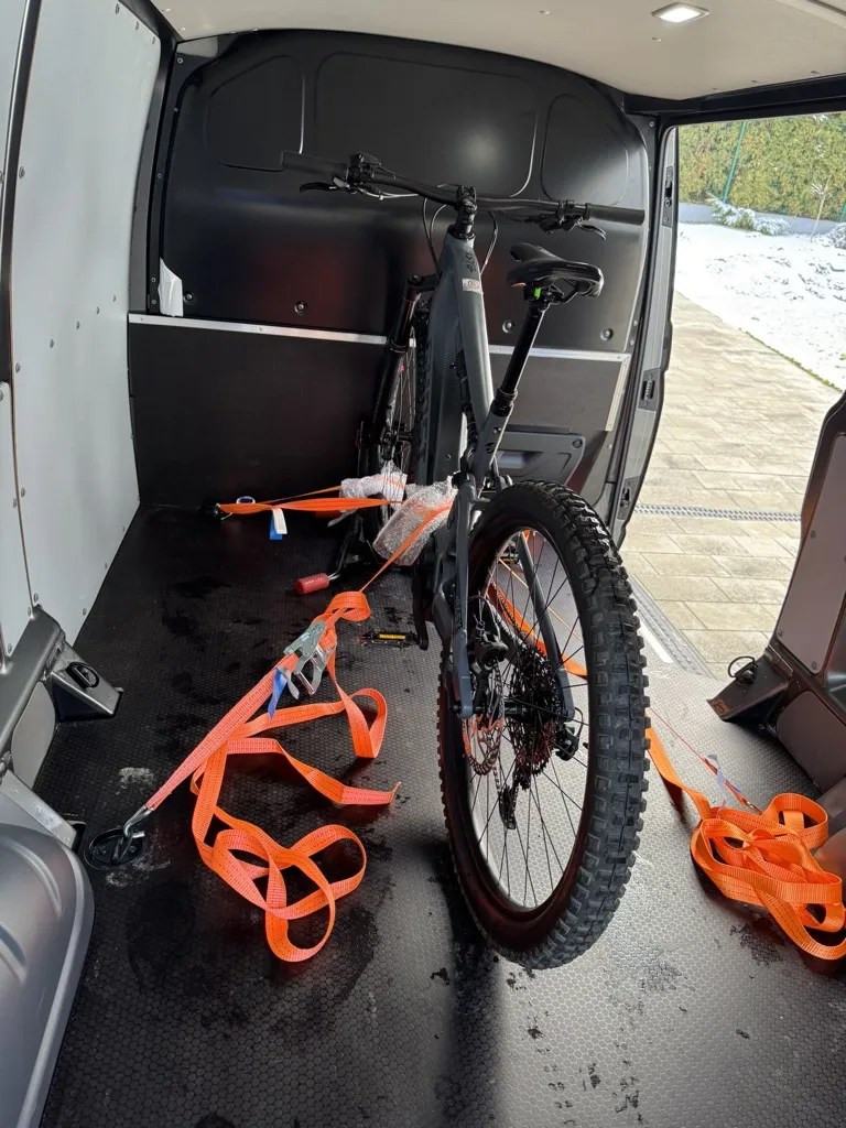Rower górski Ghost zabezpieczony pasami w przestrzeni ładunkowej busa - ujęcie 2