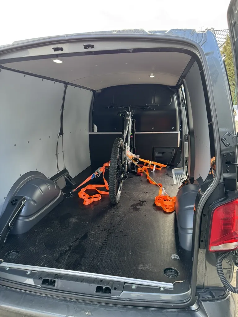 Rower górski Ghost zabezpieczony pasami w przestrzeni ładunkowej busa - ujęcie 4